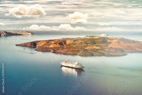 Beautiful landscape with sea view. Cruise liner at the sea near the Nea Kameni, a small Greek island in the Aegean Sea near Santorini, cyclades, Greece