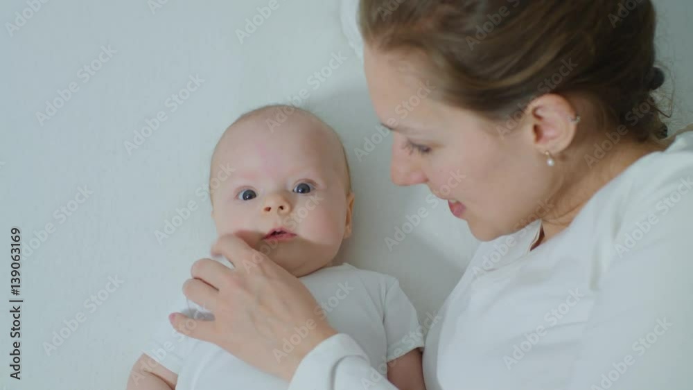 Mother with baby in bed cuddling. Mother and her Newborn Baby. Happy Mother and Baby kissing and hugging. Motherhood Beautiful Happy Family Footage. Slow Motion Mother with baby in bed cuddling. Mother and her Newborn Baby. Happy Mother and Baby kissing and hugging. Motherhood Beautiful Happy Family Footage. Slow Motion