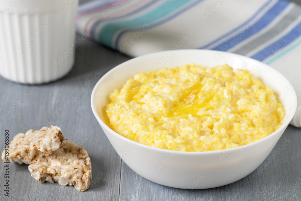 Corn porridge in white bowl on wooden table Corn porridge in white bowl on wooden table