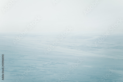A beautiful, minimalist landscape of flat, snowy Norwegian field. Clean, light, high key, decorative look. photo