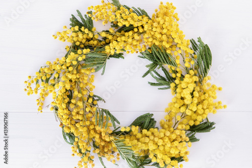 Frame from fresh mimosa flower on wooden table with space for text
