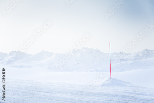 A beautiful, minimalist landscape of snowy Norwegian field with a red pole. Clean, light, high key, decorative look.