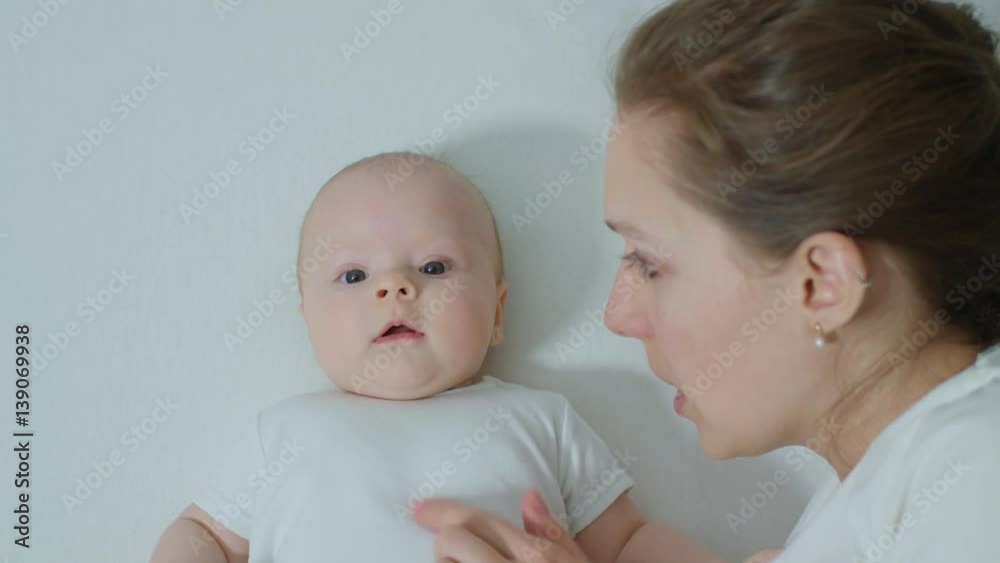 Mother with baby in bed cuddling. Mother and her Newborn Baby. Happy Mother and Baby kissing and hugging. Motherhood Beautiful Happy Family Footage. Slow Motion Mother with baby in bed cuddling. Mother and her Newborn Baby. Happy Mother and Baby kissing and hugging. Motherhood Beautiful Happy Family Footage. Slow Motion