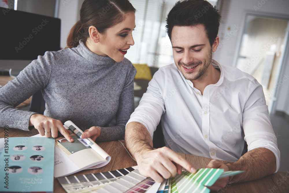 Business couple reviewing patterns at office Business couple reviewing patterns at office