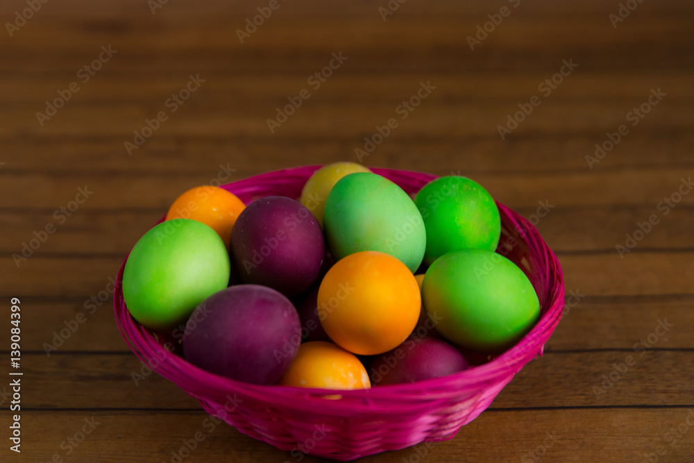 Easter, Easter eggs in basket on a brown wooden background