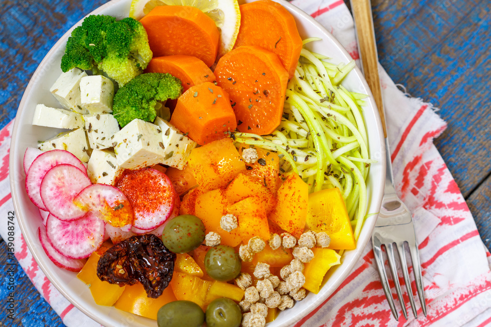 Vegan Buddha bowl - zucchini pasta, sweet potatoes, tofu with vegetables. Love for a healthy vegan food concept Vegan Buddha bowl - zucchini pasta, sweet potatoes, tofu with vegetables. Love for a healthy vegan food concept