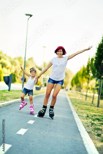 Mother and daughter rollerblading.