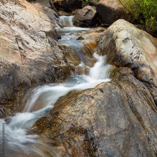 A rocky mountain river waterfall scene with large boulders in Vietnam.