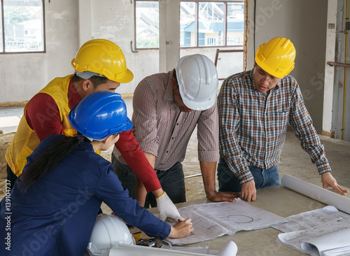 business people group on meeting and presentation with construction engineer architect looking building model and blueprint plans
