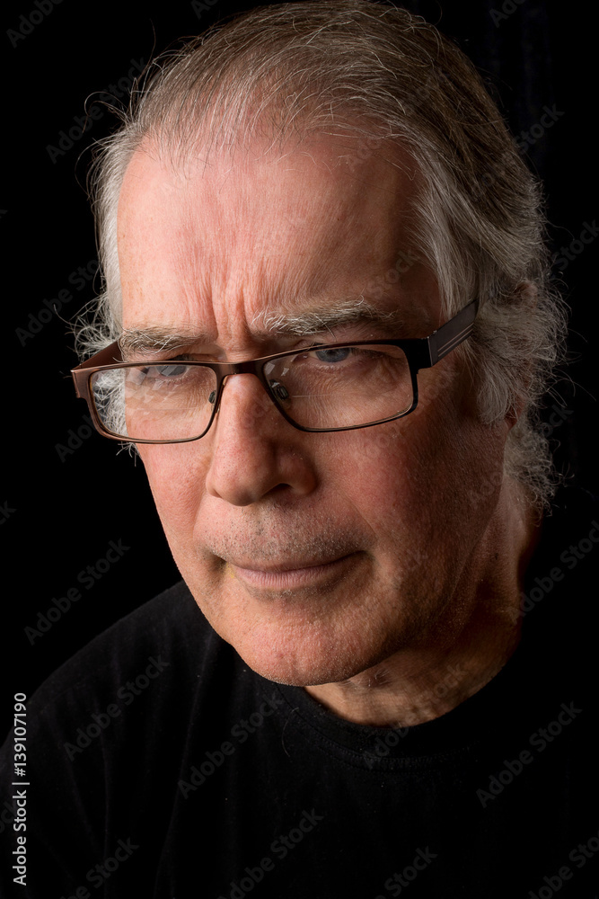 close up portrait headshot of a senior man in his 50's. male wearing black t-shirt and isolated oin black background. close up portrait headshot of a senior man in his 50's. male wearing black t-shirt and isolated oin black background.