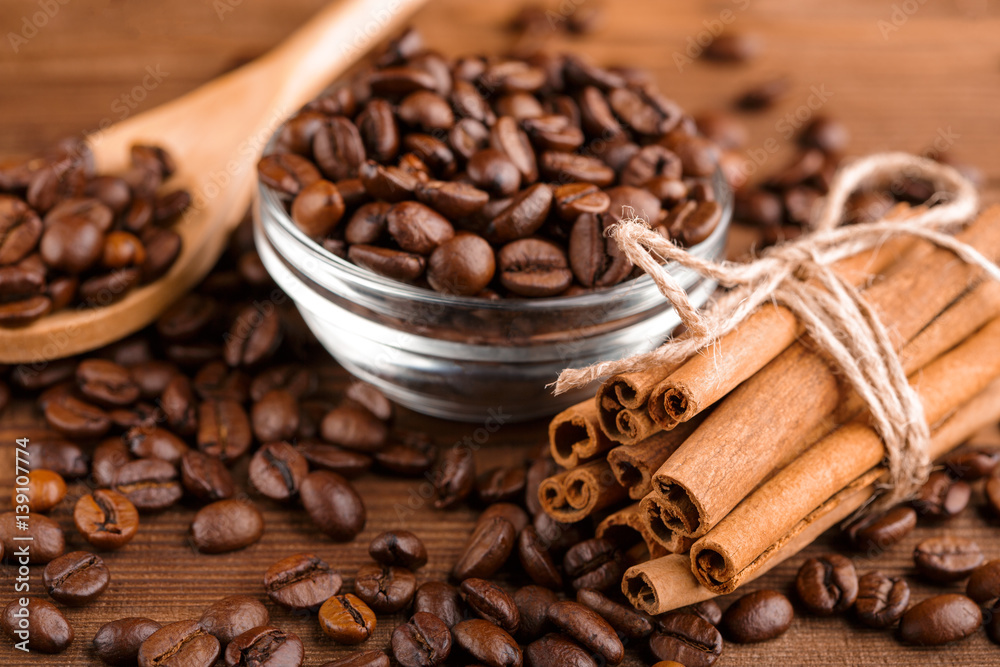 Coffee beans and cinnamon on a background of burlap. Roasted coffee beans background close up. Coffee beans pile from top with copy space for text. Seasoning. Spice. Cinnamon. Badian. Coffee house. Coffee beans and cinnamon on a background of burlap. Roasted coffee beans background close up. Coffee beans pile from top with copy space for text. Seasoning. Spice. Cinnamon. Badian. Coffee house.