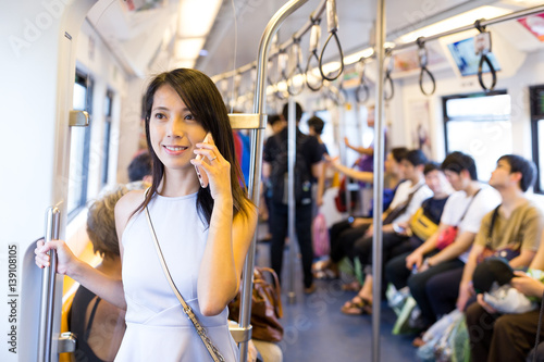 Woman talking on cellphone inside train compartment