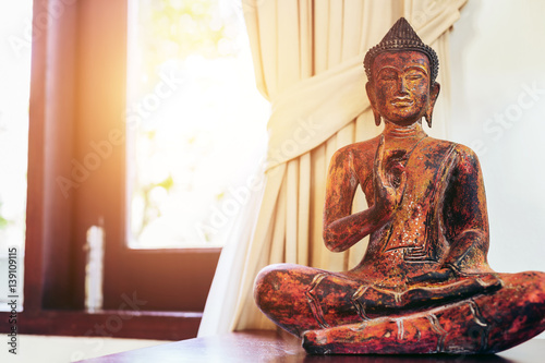 Photography Living room interior decor: buddha statue on the table near the window