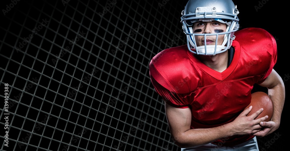 American football player playing against net on black background American football player playing against net on black background