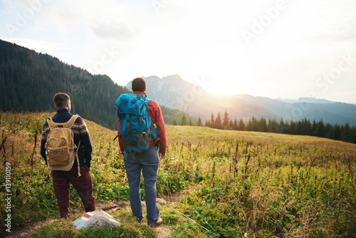 Hikers admiring the sunrise while trekking in the wilderness
