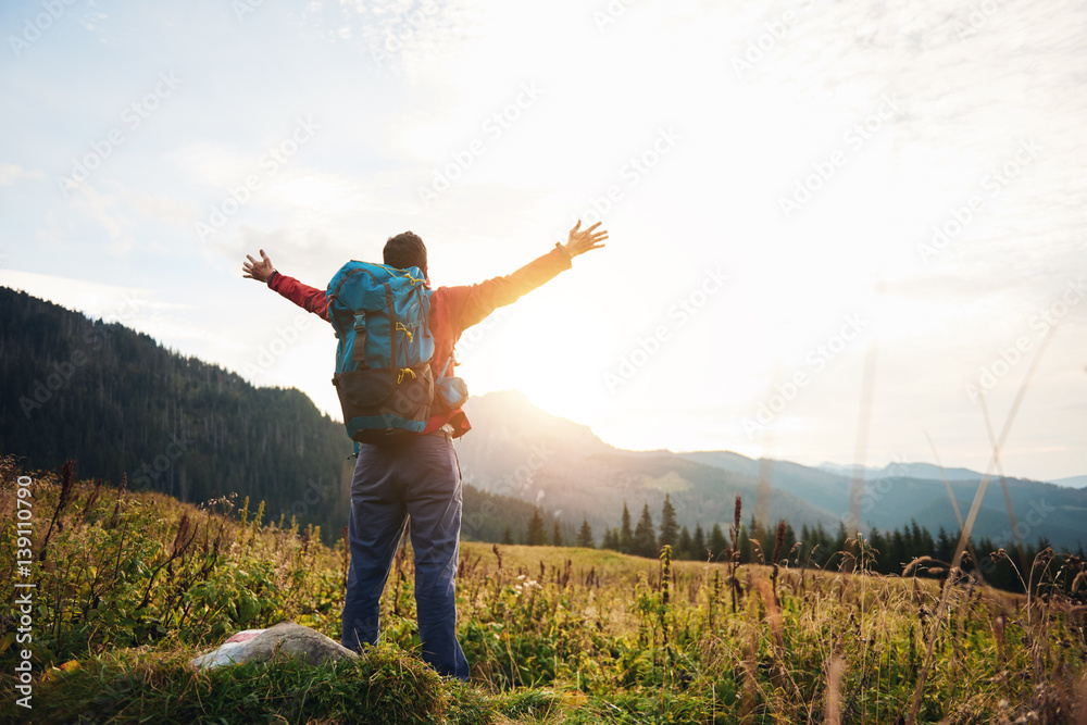 Hiker with arms raised to the sky embracing the sunrise Hiker with arms raised to the sky embracing the sunrise