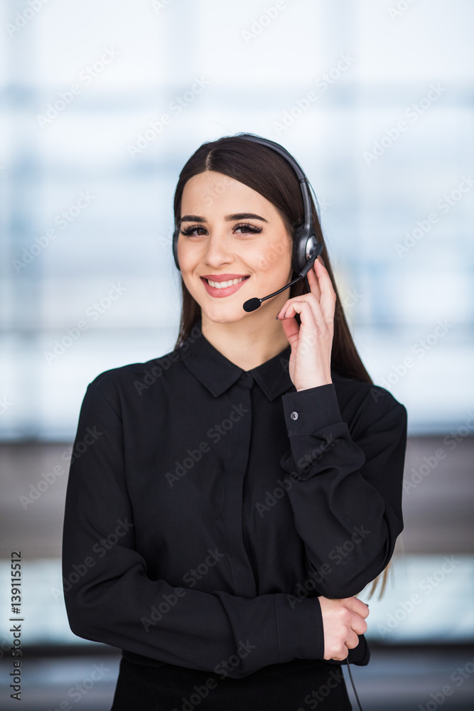 Portrait of happy smiling female customer support phone operator at workplace background Portrait of happy smiling female customer support phone operator at workplace background