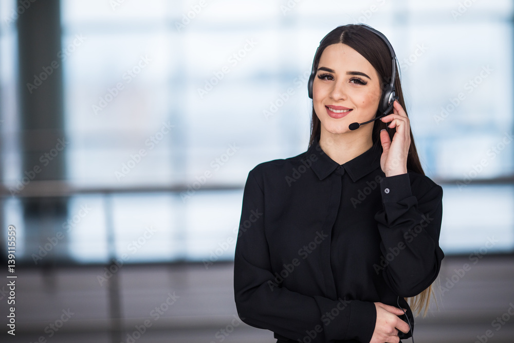 Portrait of happy smiling female customer support phone operator at workplace background Portrait of happy smiling female customer support phone operator at workplace background