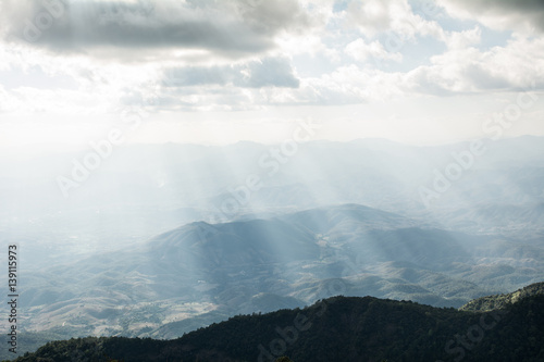 Beautiful sun rays through the clouds over mountains,evening light,Amazing scene
