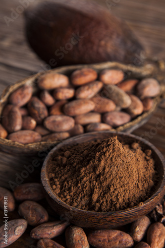 Cocoa beans in the dry cocoa pod fruit on wooden background
