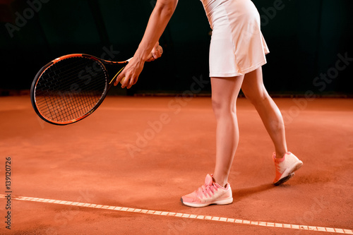 Legs of female tennis player on tennis court
