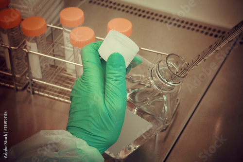 Lab technician takes sample from tube for test, close up photo