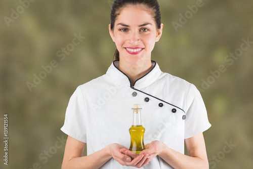 woman chef is holding a bottle of olive oil isolated in olive green background