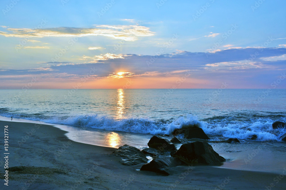 Obraz premium Rock Jetty on Beach Beneath A Summer Sunrise