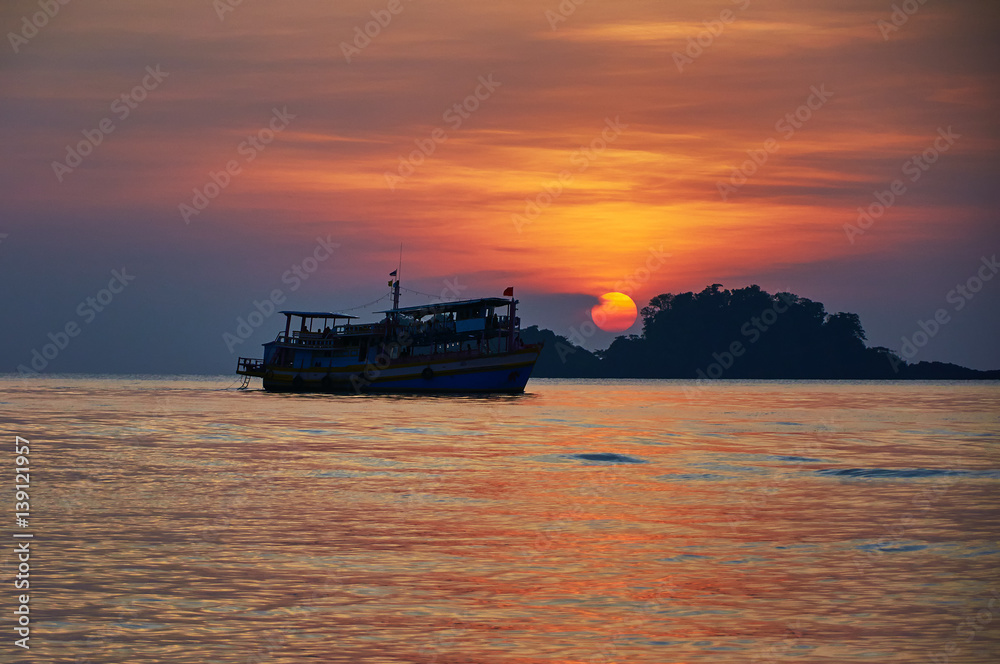 Silouette of tourist boat at sunset, Asia