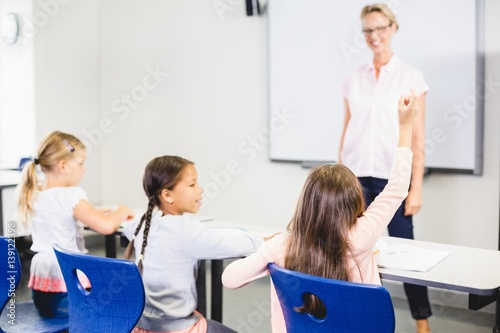 Kids raising hand in classroom