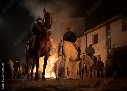 Fotografiet Horses jumping above the fire without fear