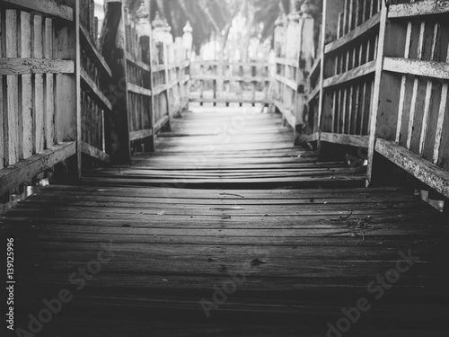 Old wooden bridge path across the lake/river to dead end,  selective focus, black and white © Waithaya