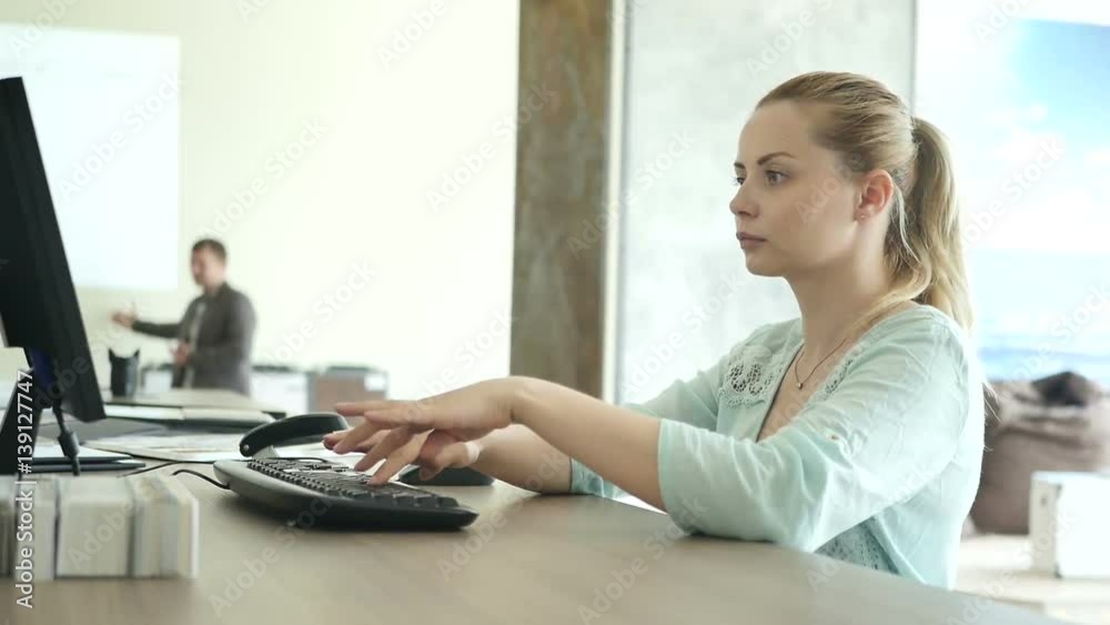 The young woman typing on the computer in the shop
