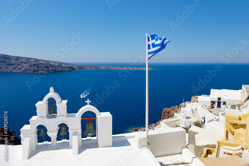 View on calm sea surface through traditional Greek white church arch