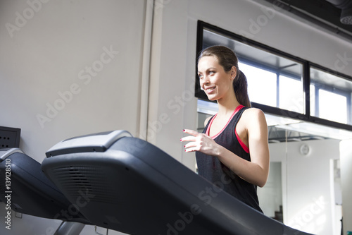 Young woman exercise on the treadmill at the gym photo