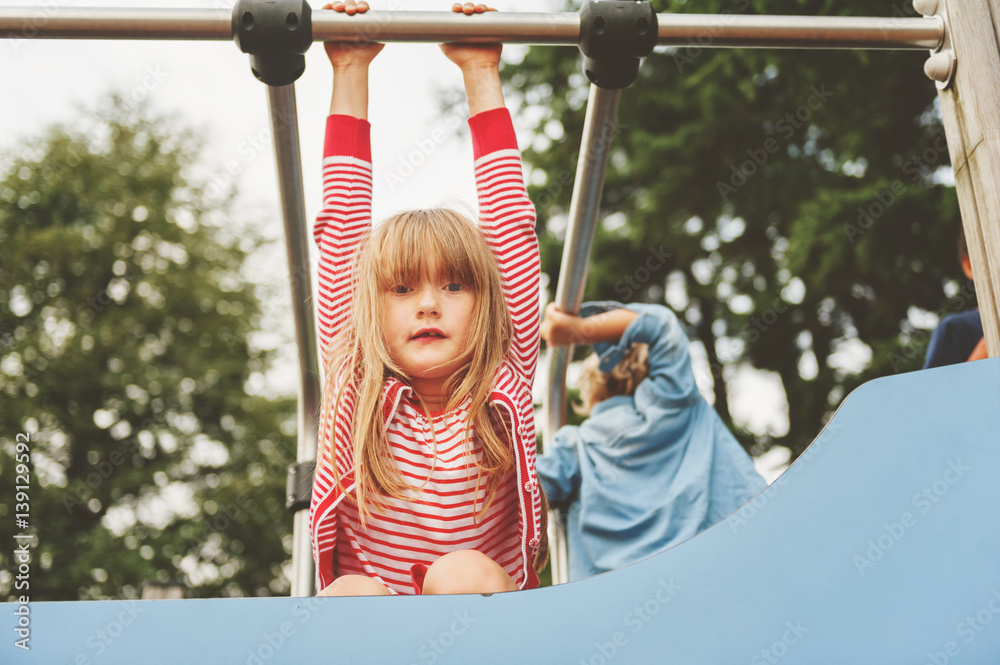 Fototapeta premium Happy kid girl having fun on playground