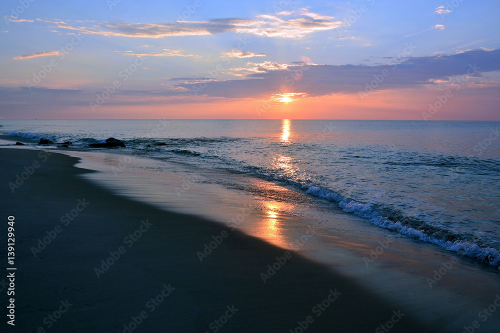 Naklejka premium Soothing Summer Seas at Sunrise on the Shore