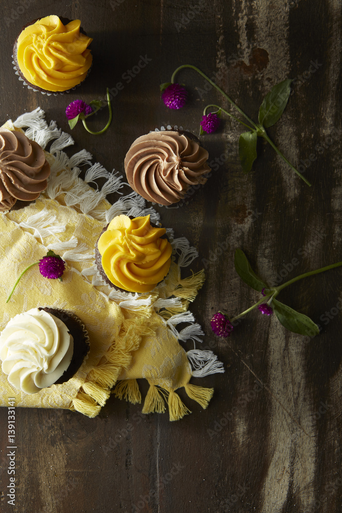 Cupcakes with Flowers on rustic wood table Cupcakes with Flowers on rustic wood table