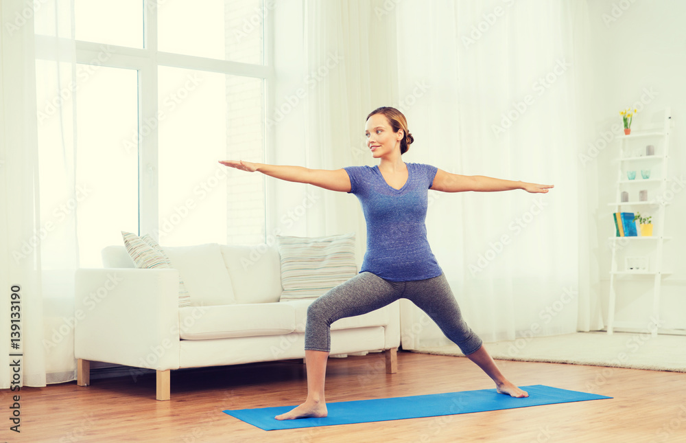 woman making yoga warrior pose on mat