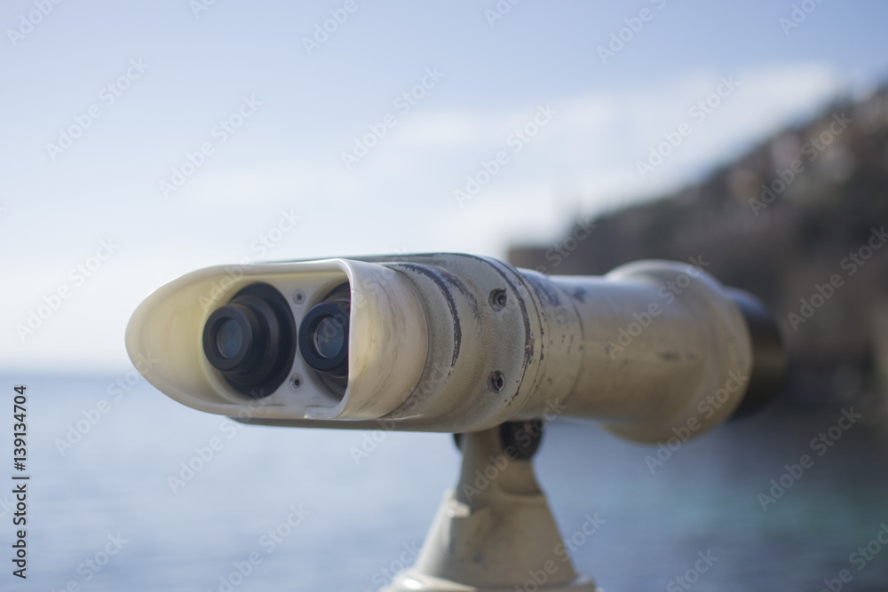 Coin operated binoculars and panoramic view of the city on a sunny day