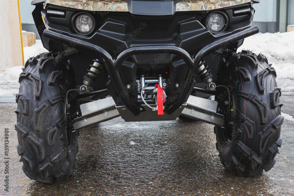 Headlights of black ATV quadbike isolated on city pavement, close up Headlights of black ATV quadbike isolated on city pavement, close up