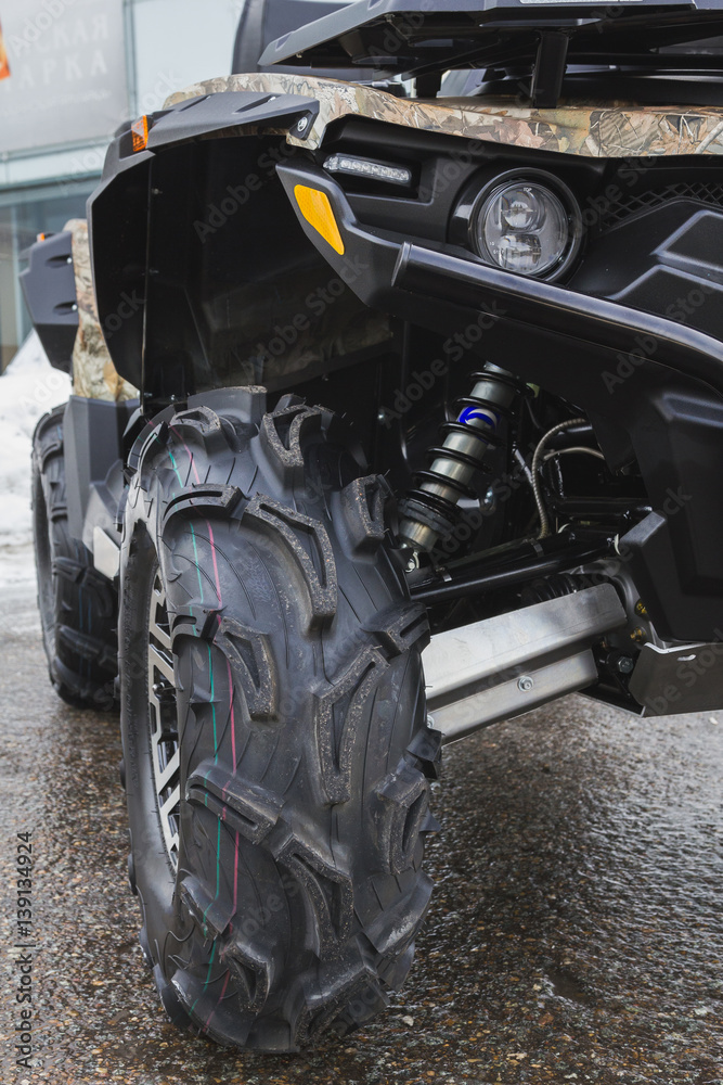Black ATV quadbike isolated on city pavement, close up