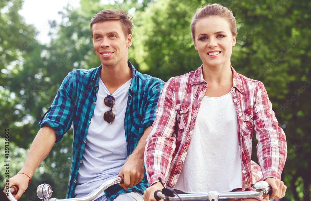 Young couple of hipsters riding a bicycle. Date in old town. Love, relationship, romance concept. Young couple of hipsters riding a bicycle. Date in old town. Love, relationship, romance concept.
