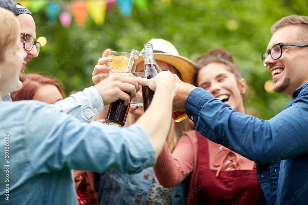 Obraz premium happy friends clinking glasses at summer garden