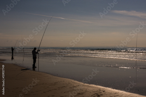 angler with fishing rod on the beach