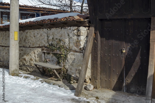 A main entrance in yard of old house with bench, town Koprivshtitsa, Bulgaria  