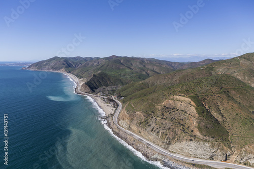 Aerial of Pacific Coast Highway winding past Sycamore Cove State Park north of Malibu in Southern California. 