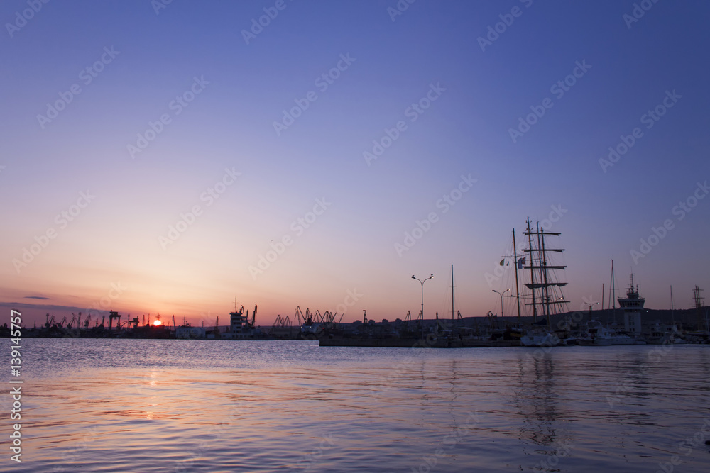 Red sunset over the port with water reflections