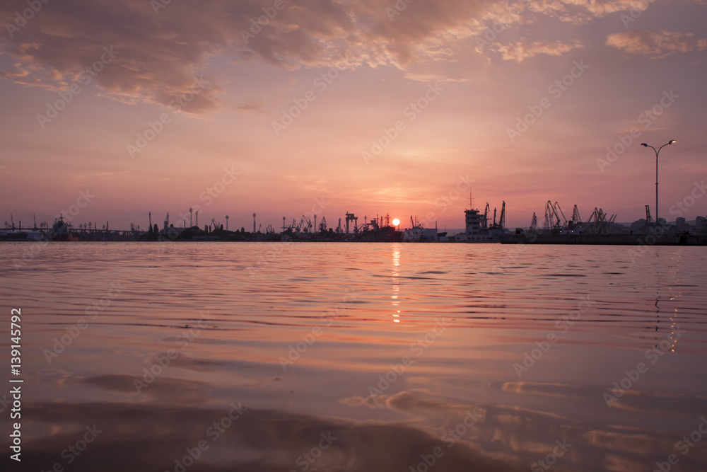 Red sunset over the port with water reflections