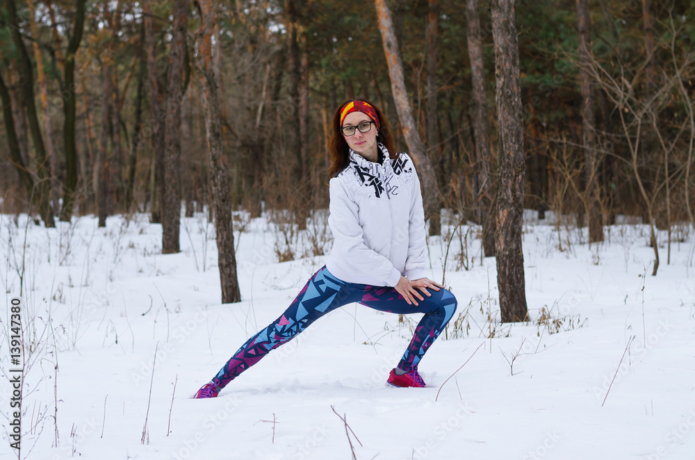 Sport Young woman doing fitness in the winter forest.